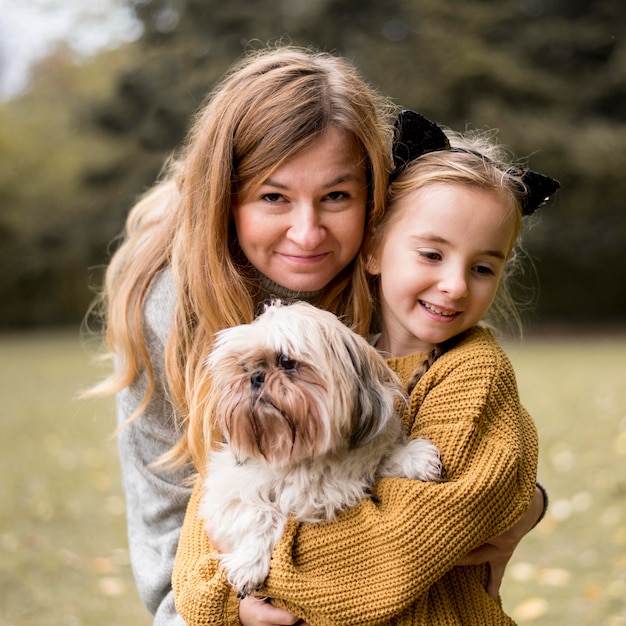 Medium shot moeder en kind knuffelen hond