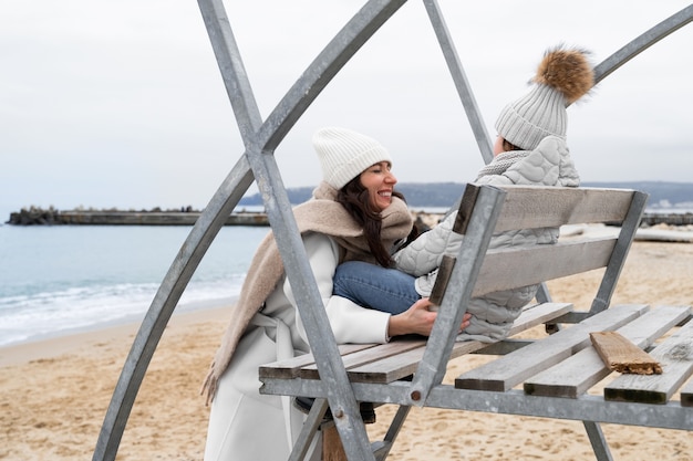 Gratis foto medium shot moeder en kind op het strand