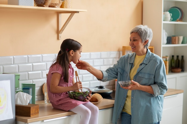 Medium shot oma en meisje die samen koken