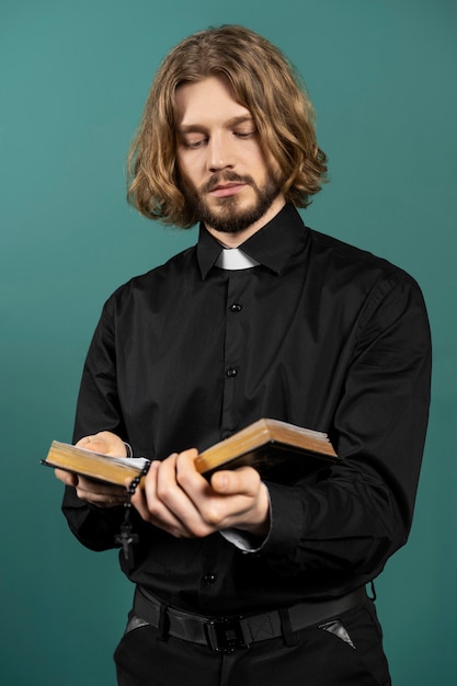 Medium shot priester die bijbel leest