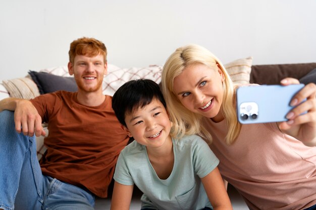 Medium shot smiley familie selfie te nemen