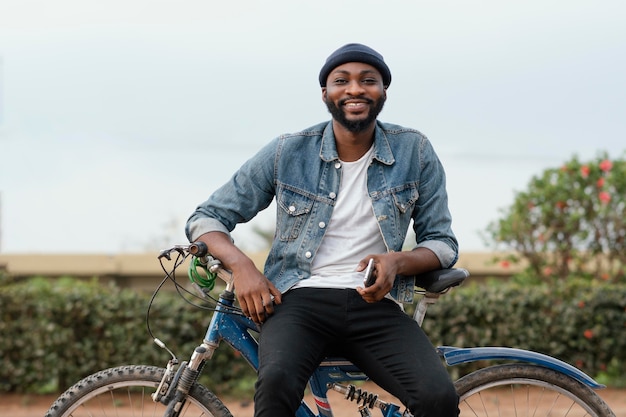 Medium shot smiley man met fiets in de natuur