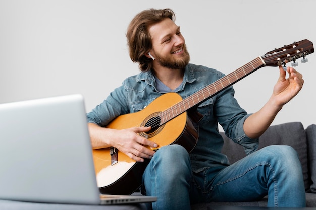 Gratis foto medium shot smiley man met gitaar