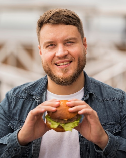 Medium shot smiley man met hamburger