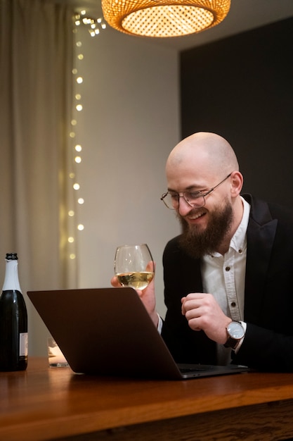 Gratis foto medium shot smiley man met laptop binnenshuis