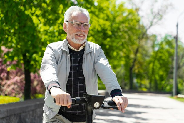 Medium shot smiley man met scooter