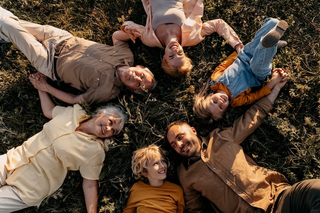 Gratis foto medium shot smiley mensen die op gras liggen