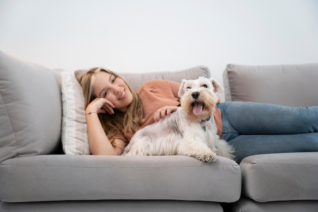 Medium shot smiley vrouw en hond op de bank