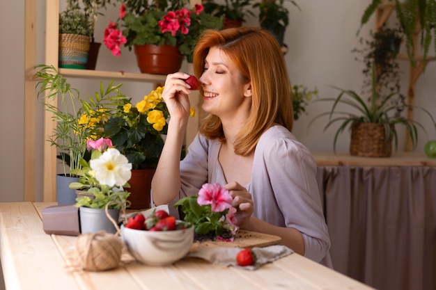 Gratis foto medium shot smiley vrouw met aardbei