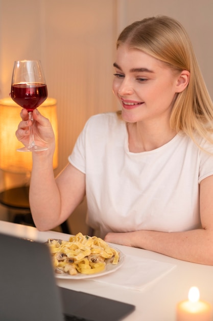 Medium shot smiley vrouw met eten en wijn