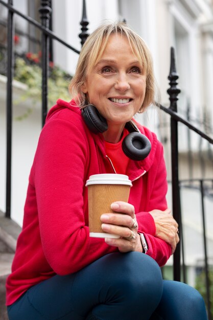 Medium shot smiley vrouw met koffie