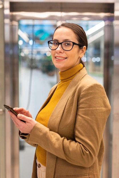 Medium shot smiley vrouw met telefoon