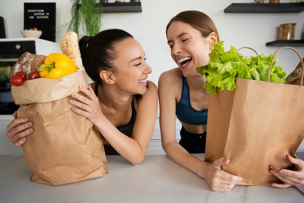 Medium shot smiley vrouwen met boodschappen