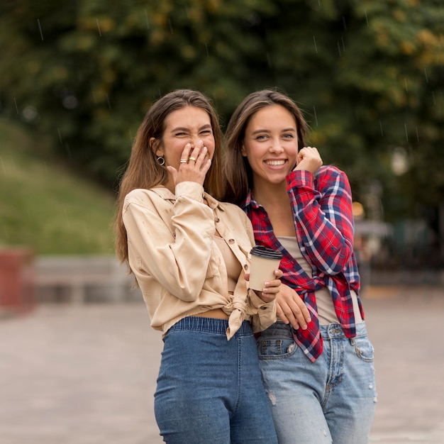 Gratis foto medium shot smileymeisjes met koffiekopje