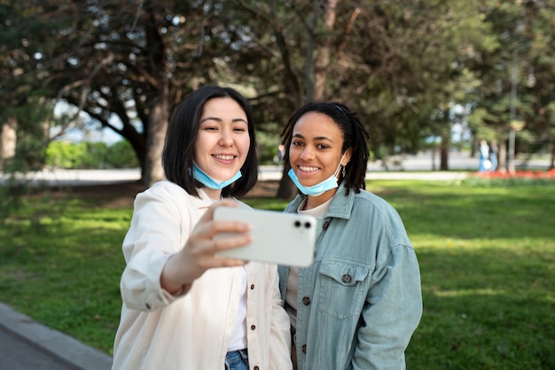 Medium shot smileyvrienden die selfie maken