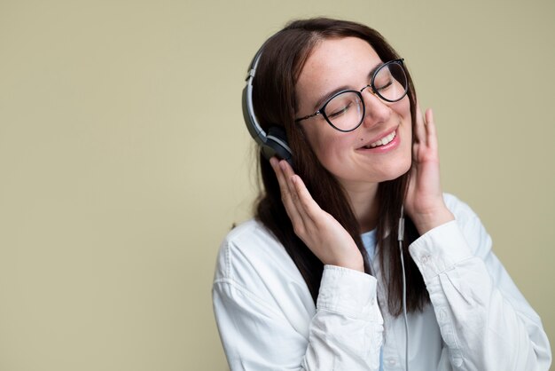 Medium shot smileyvrouw die naar muziek luistert