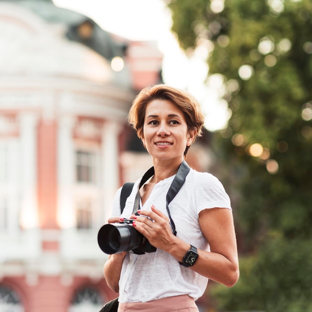 Gratis foto medium shot smileyvrouw met camera