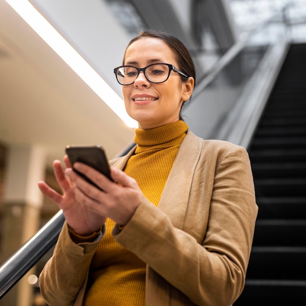 Medium shot smileyvrouw met telefoon