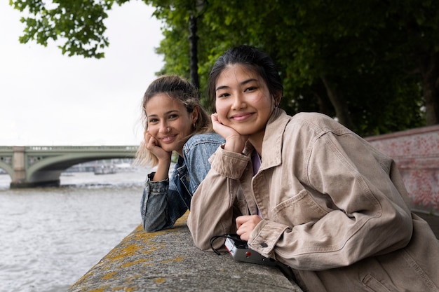 Gratis foto medium shot smileyvrouwen buitenshuis