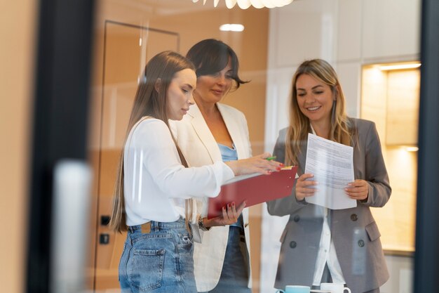 Gratis foto medium shot smileyvrouwen die samenwerken