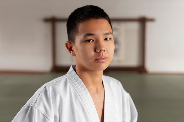 Gratis foto medium shot tiener die taekwondo beoefent