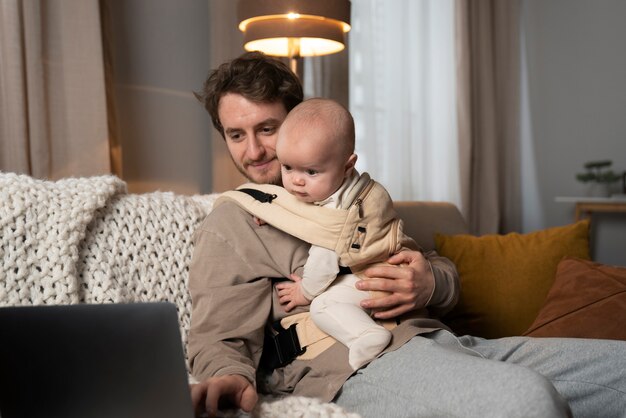 Medium shot vader aan het werk terwijl hij de baby vasthoudt