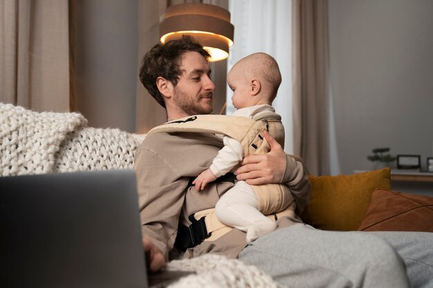 Medium shot vader aan het werk terwijl hij de baby vasthoudt