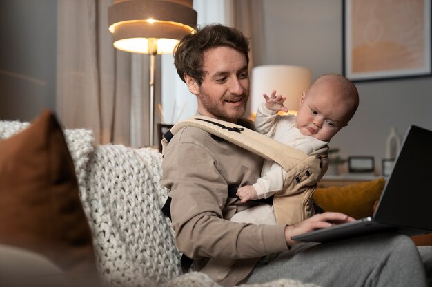 Medium shot vader aan het werk terwijl hij de baby vasthoudt