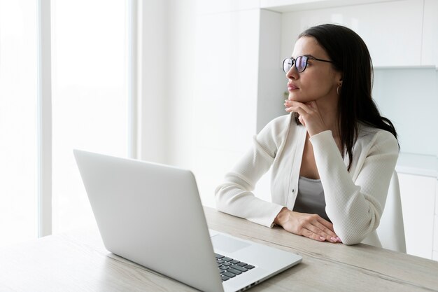 Medium shot vermoeide vrouw die thuis werkt