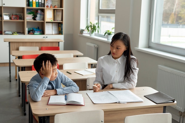 Gratis foto medium shot verveelde jongen op school