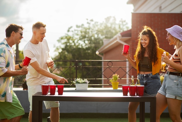 Gratis foto medium shot vrienden die bierpong spelen