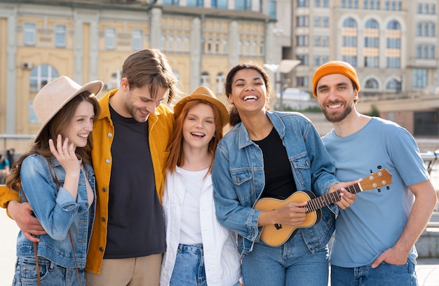 Medium shot vrienden die rondhangen met gitaar