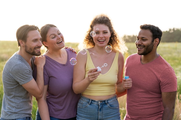 Medium shot vrienden die zeepbellen maken