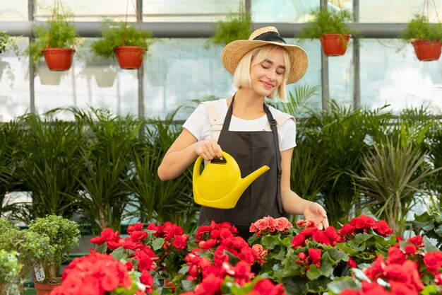 Medium shot vrouw die bloemen water geeft