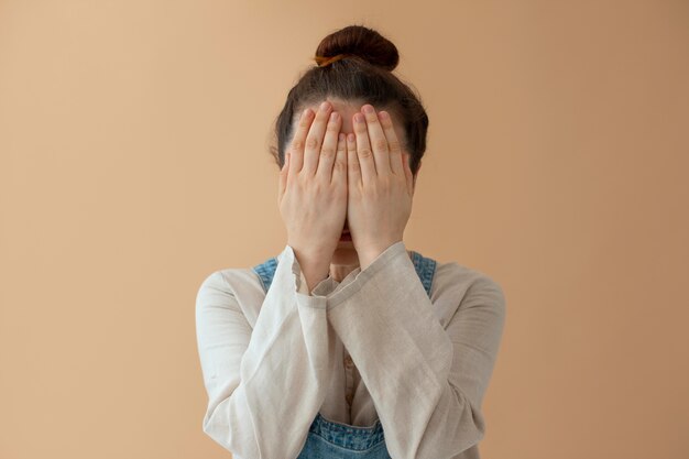 Medium shot vrouw die haar gezicht bedekt