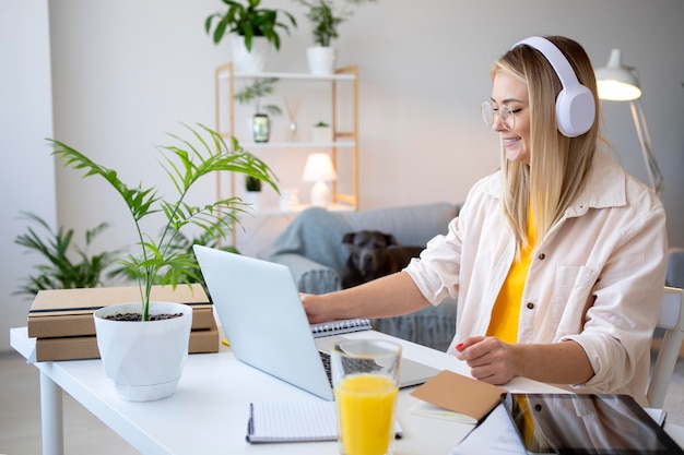 Medium shot vrouw die met een koptelefoon werkt