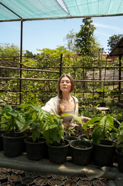 Medium shot vrouw die planten controleert