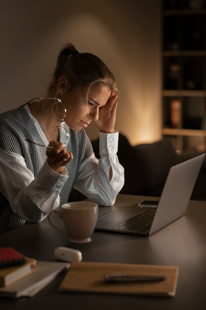 Medium shot vrouw die 's avonds laat aan het werk is