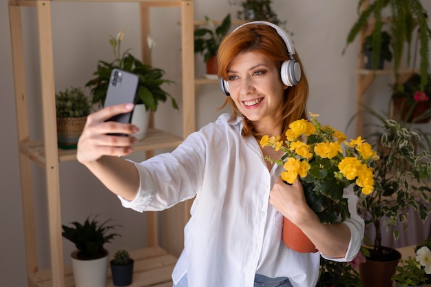 Medium shot vrouw die selfie met bloemen neemt