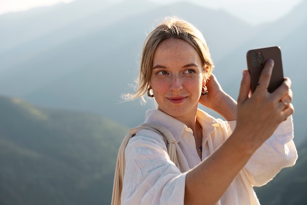 Medium shot vrouw die selfie op de berg neemt