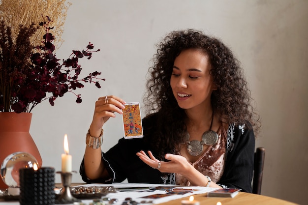 Medium shot vrouw die tarot leest aan tafel