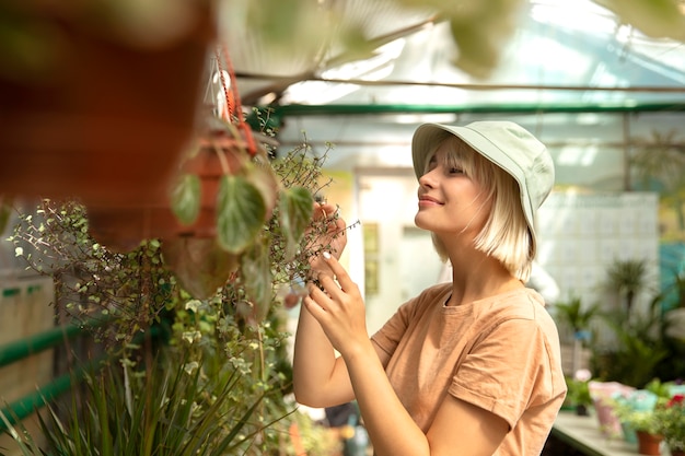 Medium shot vrouw die voor plant zorgt