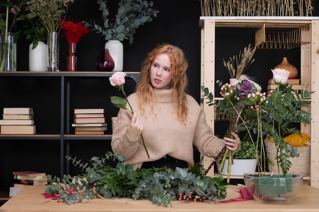 Medium shot vrouw die werkt bij bloemenwinkel