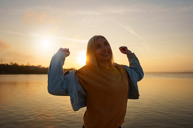 Medium shot vrouw die zich voordeed bij zonsondergang