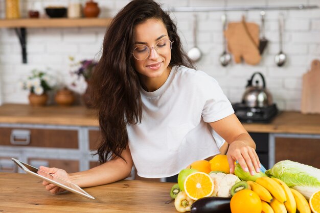 Medium shot vrouw met fruit en tablet