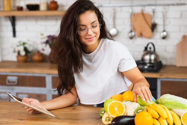 Medium shot vrouw met fruit en tablet