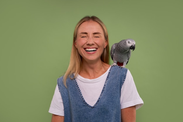 Gratis foto medium shot vrouw met papegaai in studio