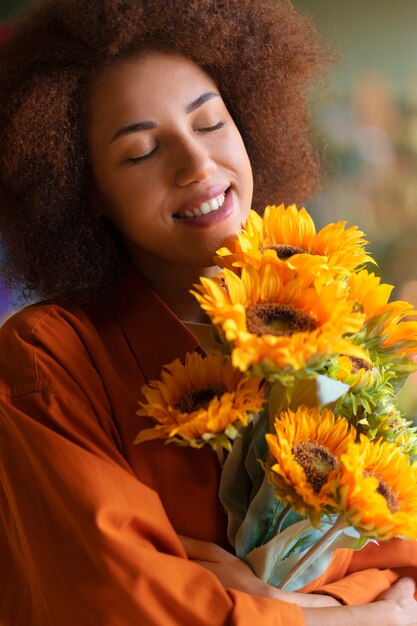 Medium shot vrouw met prachtige zonnebloemen