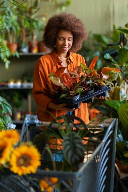 Gratis foto medium shot vrouw met prachtige zonnebloemen