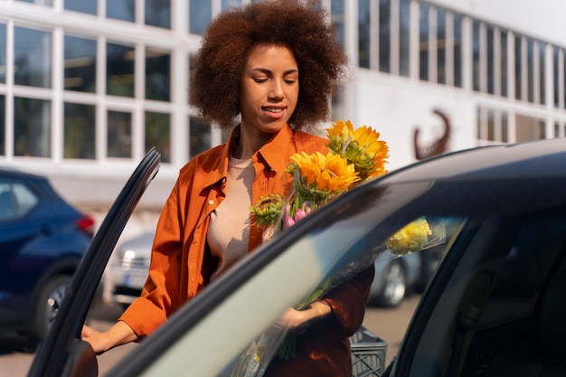 Gratis foto medium shot vrouw met prachtige zonnebloemen